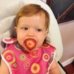 Baby eating a strawberry