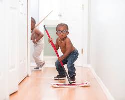 young boy sweeping hallway